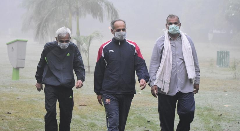 People wear masks to protect themselves as the levels of pollution increased in Gurugram. (Photo: IANS)