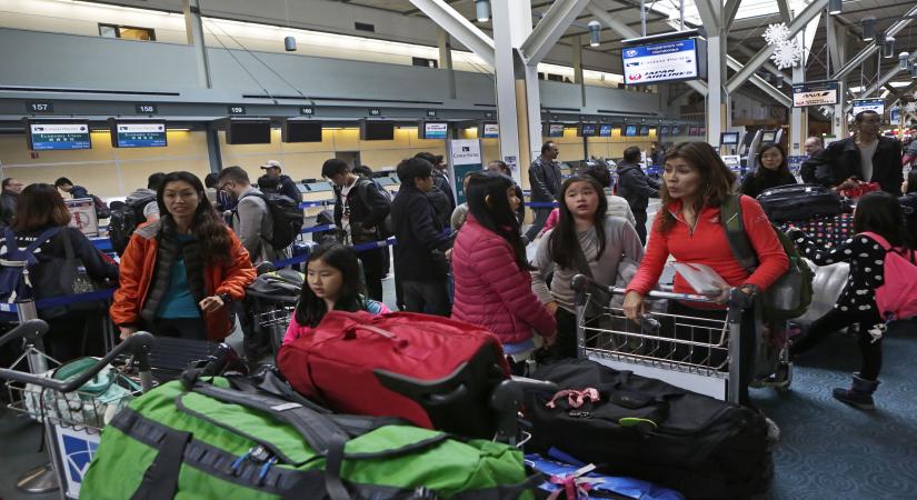 VANCOUVER (CANADA), Dec. 20, 2014 (Xinhua) -- Travellers wait for their flights at Vancouver international airport in Vancouver, Canada, Dec.19, 2014. Vancouver International Airport meets one of the busiest days with approaching winter holidays. (Xinhua/Liang Sen/IANS)