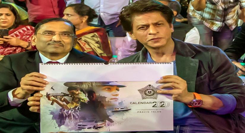 Mumbai: A copy of the Mumbai Police Calendar being presented to Bollywood superstar Shah Rukh Khan at the grand event Umang in Mumbai. (Photo: IANS)