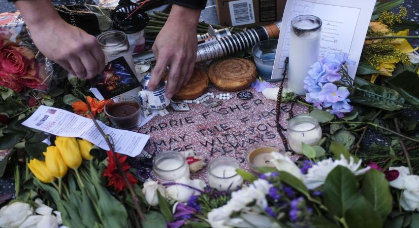 LOS ANGELES, Dec. 30, 2016 (Xinhua) -- Flowers and candles surround an impromptu memorial created on a blank Hollywood Walk of Fame star by fans of late actress and author Carrie Fisher, in Los Angeles, California, the United States, on Dec. 29, 2016. Hollywood star Debbie Reynolds died of stroke Wednesday at the age of 84, one day after her daughter Carrie Fisher's death. Carrie Fisher, the actress best known as Princess Leia in the "Star Wars" movie franchise, died at the age of 60 on Tuesday