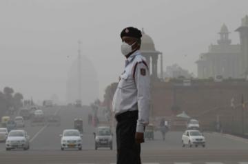A traffic police personnel wears a mask to protect himself from pollution in New Delhi. (Photo: IANS)