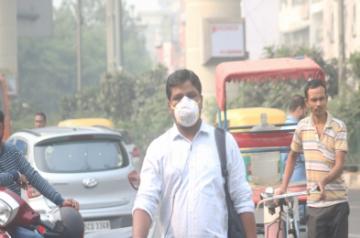 People wear masks to protect themselves from air pollution as smog continues to engulf the national capital, on Nov 4, 2019. (Photo: IANS)